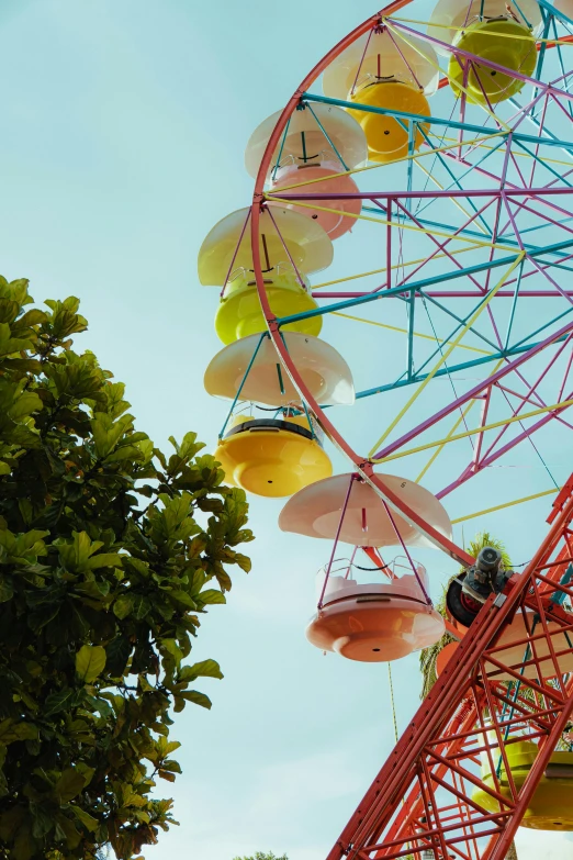 the colorful ferris wheel at a carnival is suspended by strings