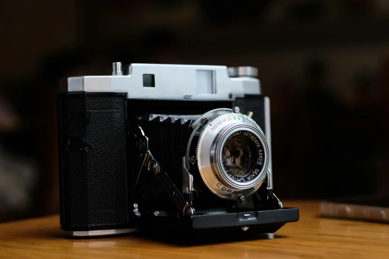 an old camera sitting on top of a wooden table