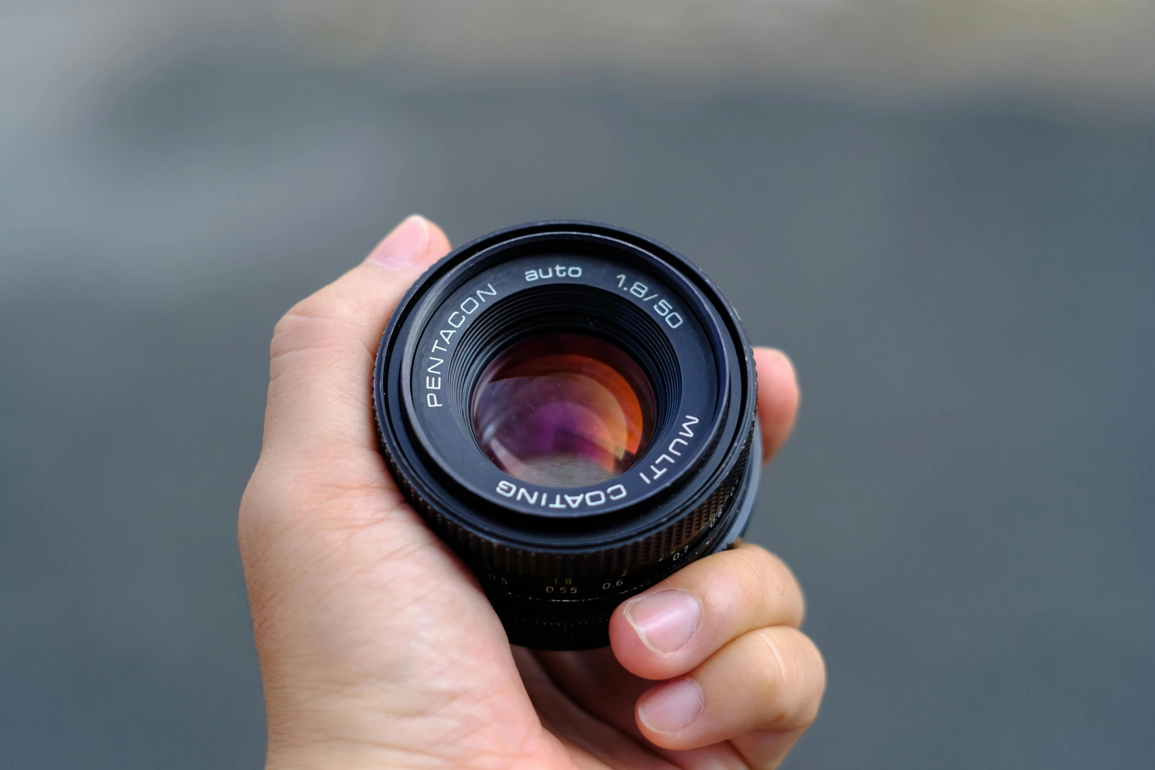 a close up of a hand holding a camera lens