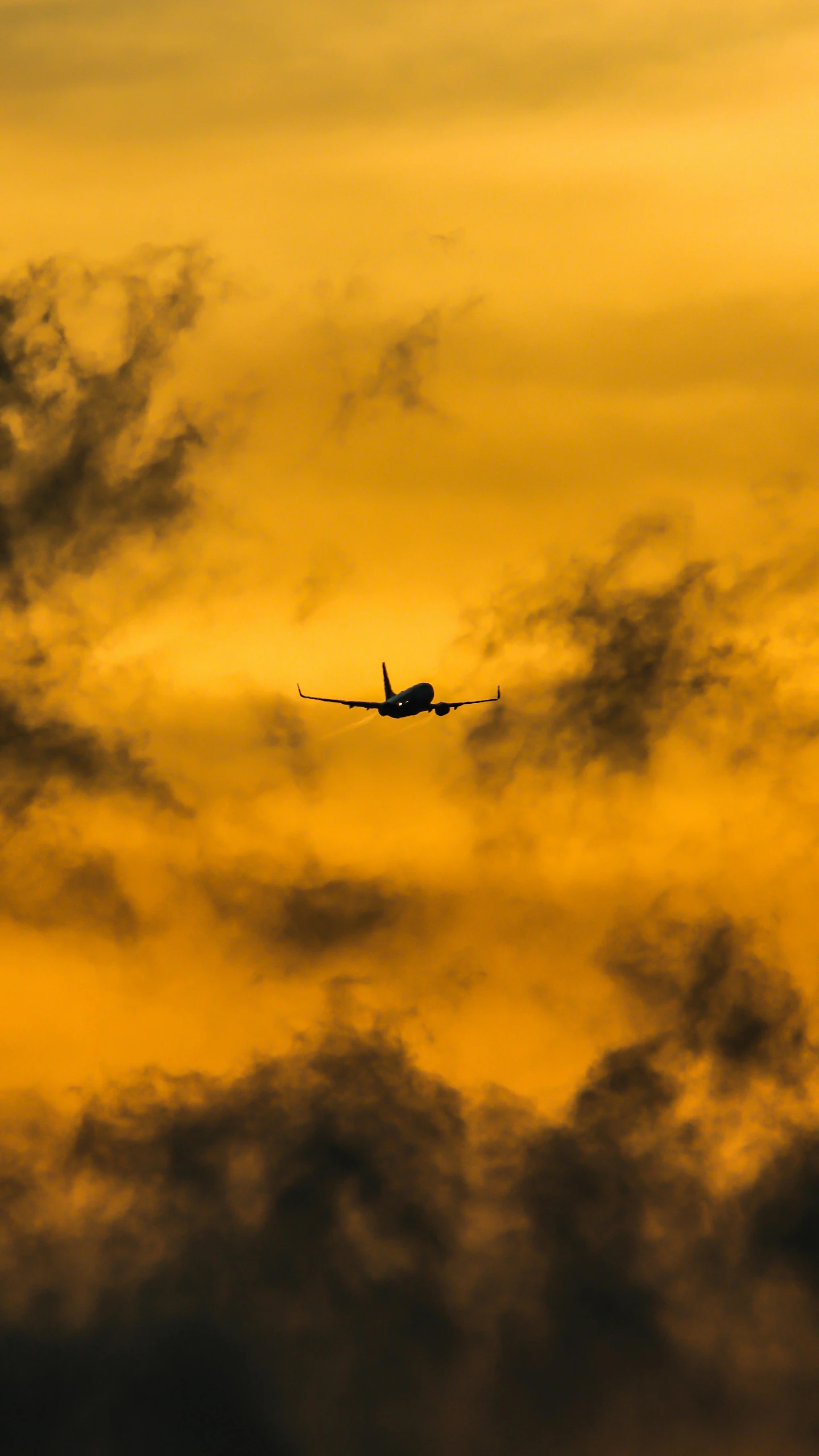 an airplane flying through the air at sunset