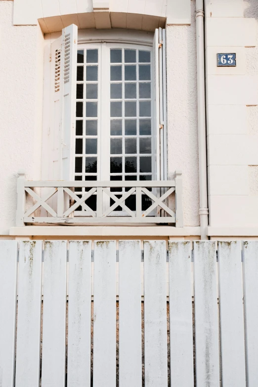 an empty balcony with a white railing and a window