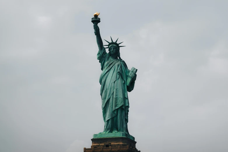 the statue of liberty is illuminated in the middle of day