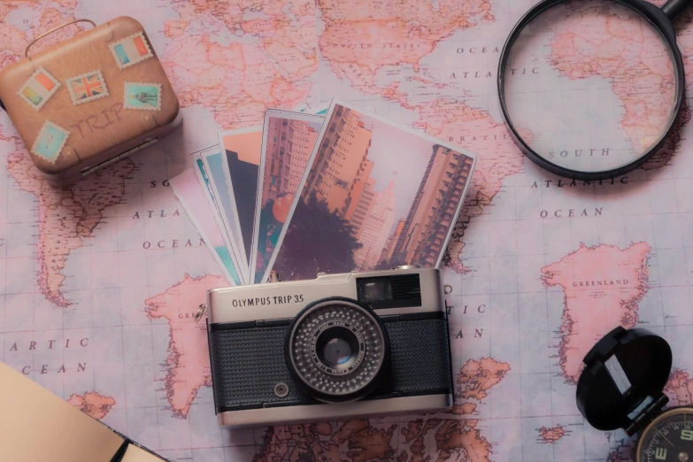 a camera, magnifier and some cards sitting on a map