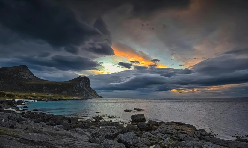 clouds rolling over the top of a mountain and sea