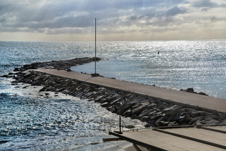 some long stone jetty with lots of water next to it