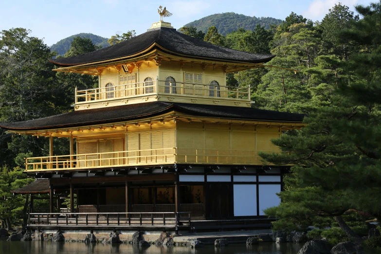 an asian style building in front of a pond