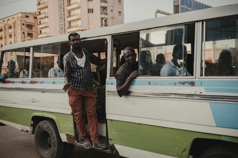 an african man standing in the door of a bus