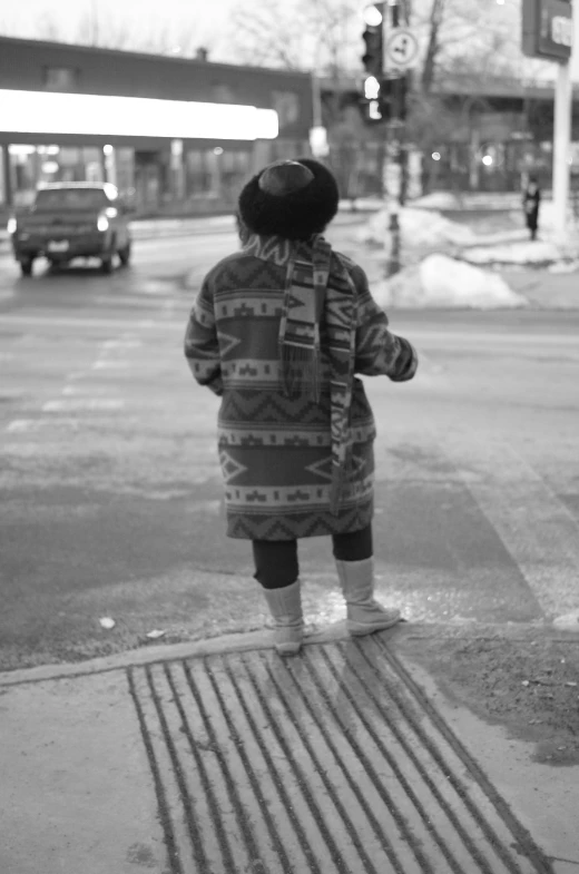 little boy watching traffic on the road in winter