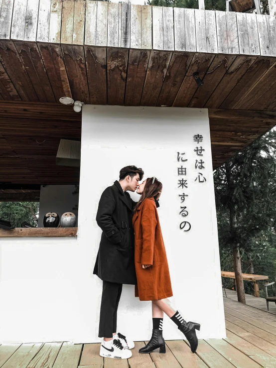 a young couple kissing in front of the japanese restaurant