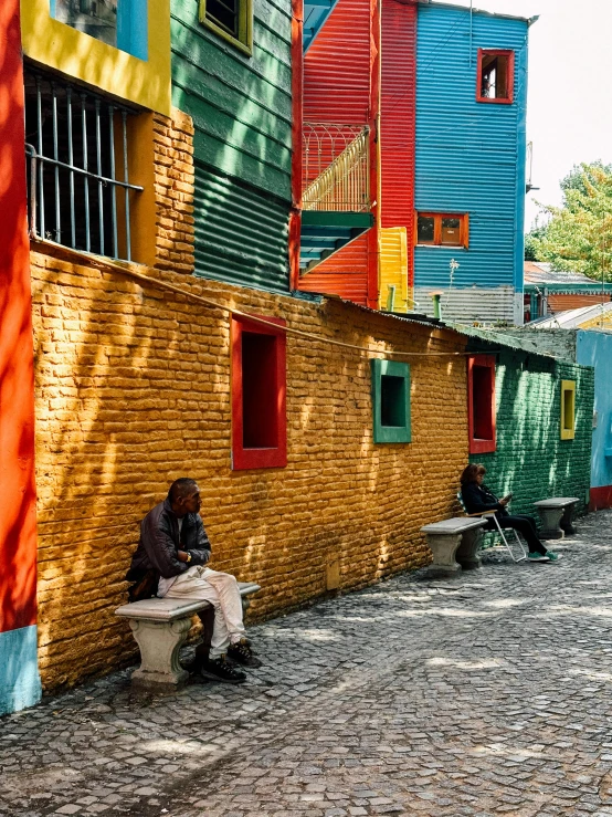 a man sitting on the sidewalk in front of a building