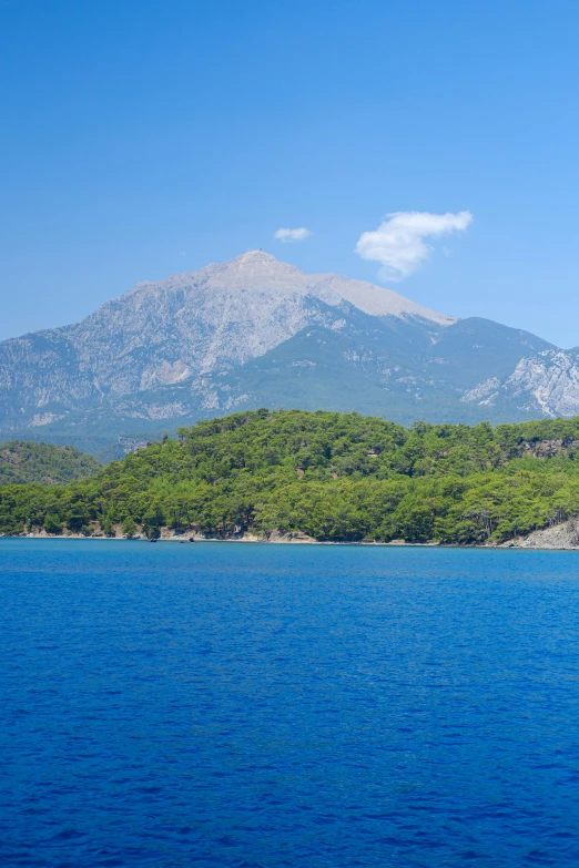 some green mountains in the distance over a blue body of water