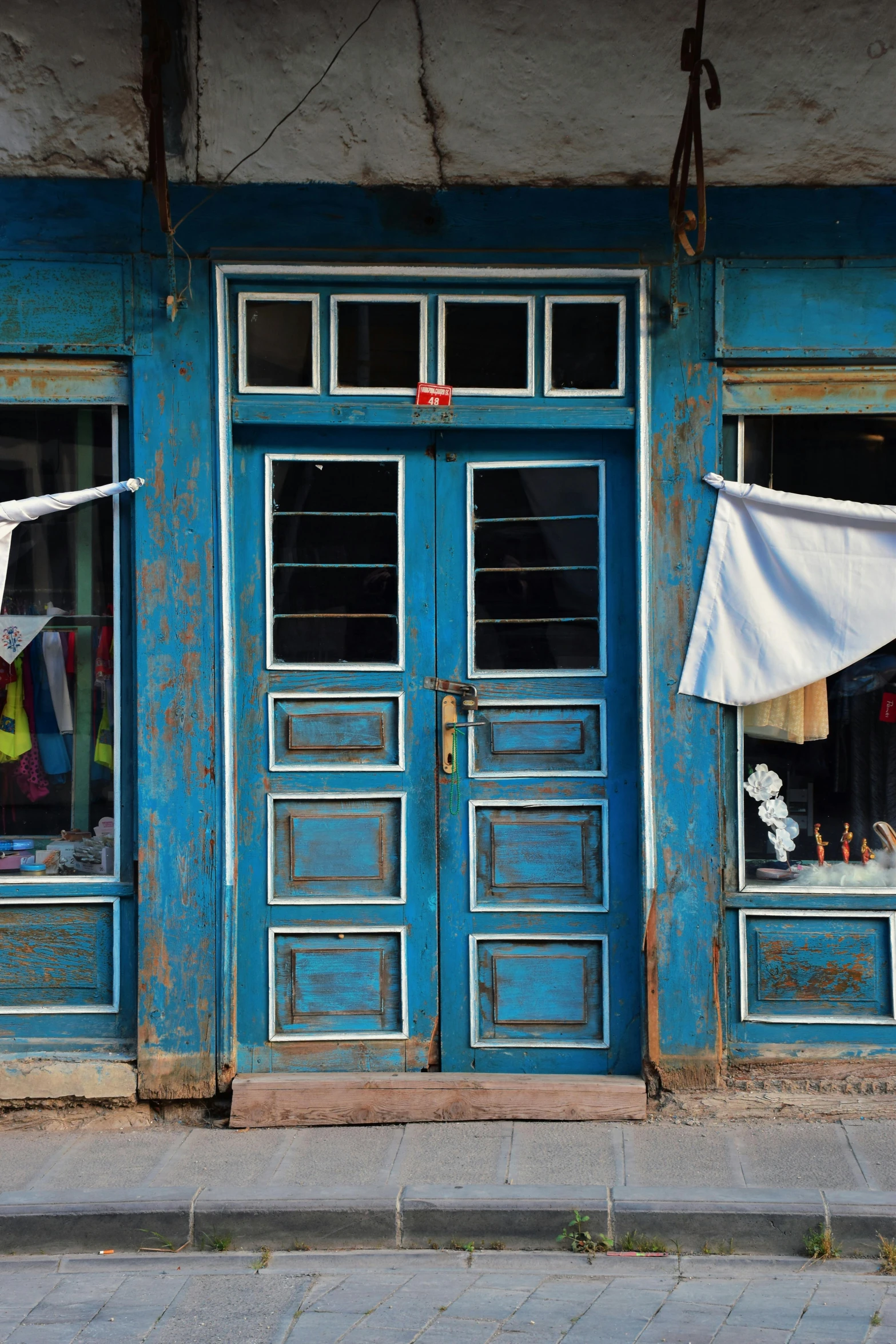 a couple of blue doors with clothes hanging on the side