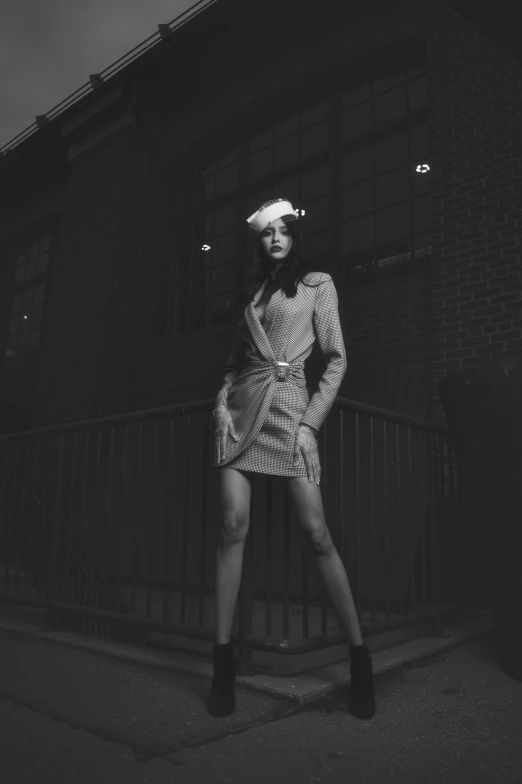 black and white image of young woman standing in dress