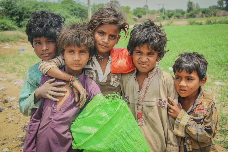 four children are standing around in the field