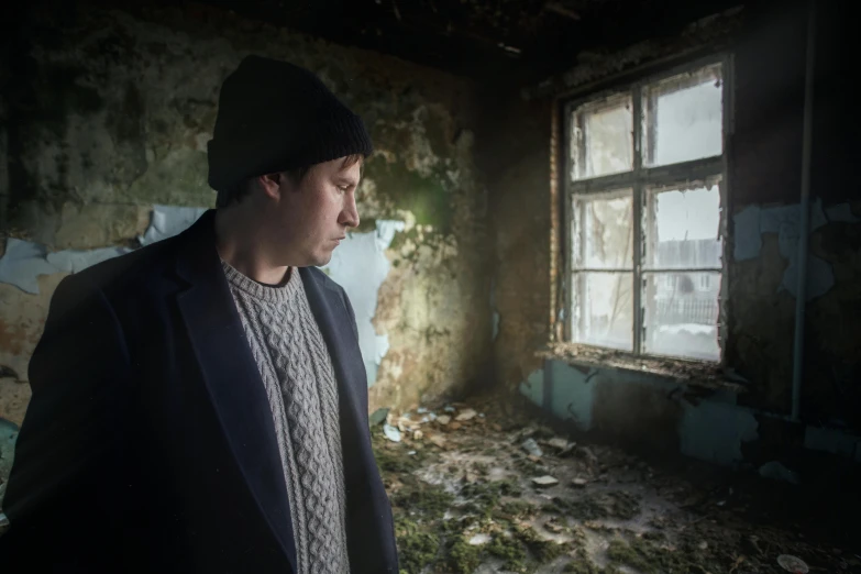 a man standing in an abandoned room staring at soing