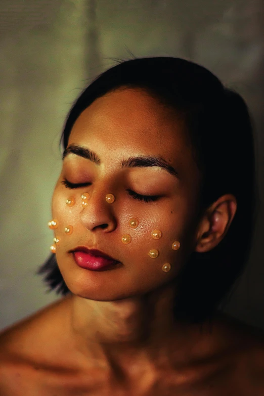 a woman wearing facial embellishment is posing for a po