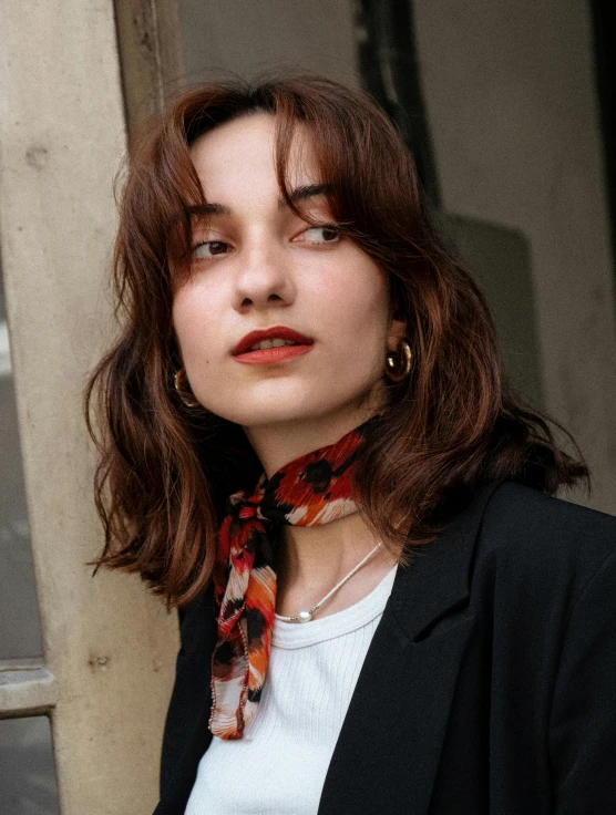 a young woman with wavy hair wearing a white t shirt and red scarves