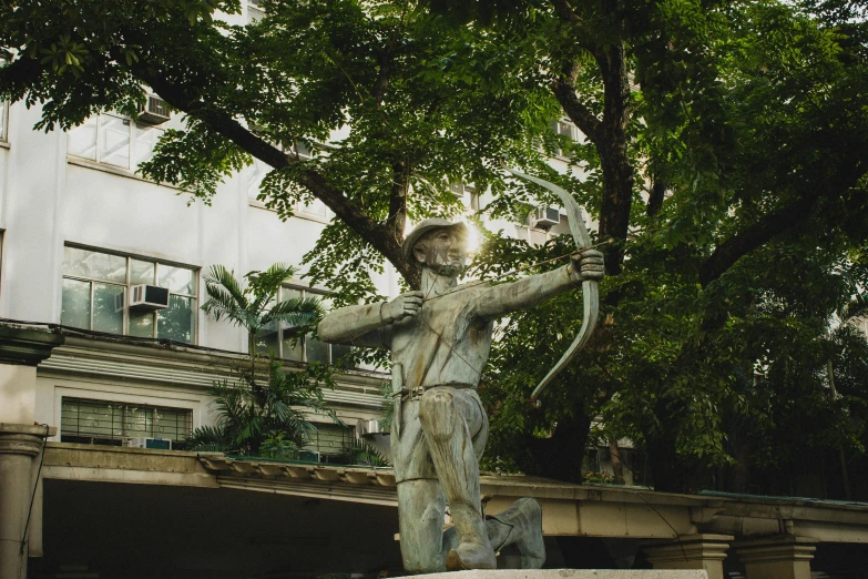 a statue of an ancient greek, holds a bow in his right hand