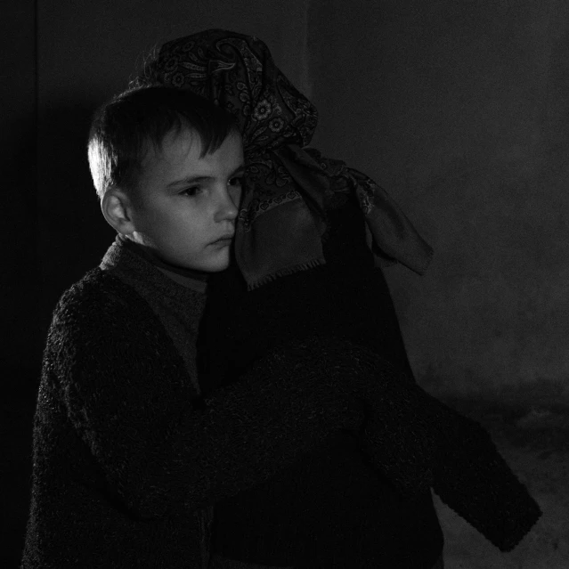 a boy is holding up a stuffed animal