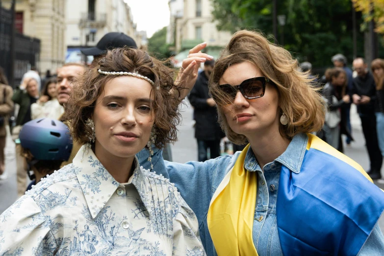 two women with sunglasses on their heads on a city street