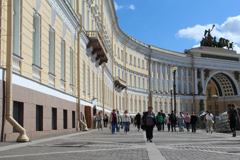 people walking down an outside area near buildings