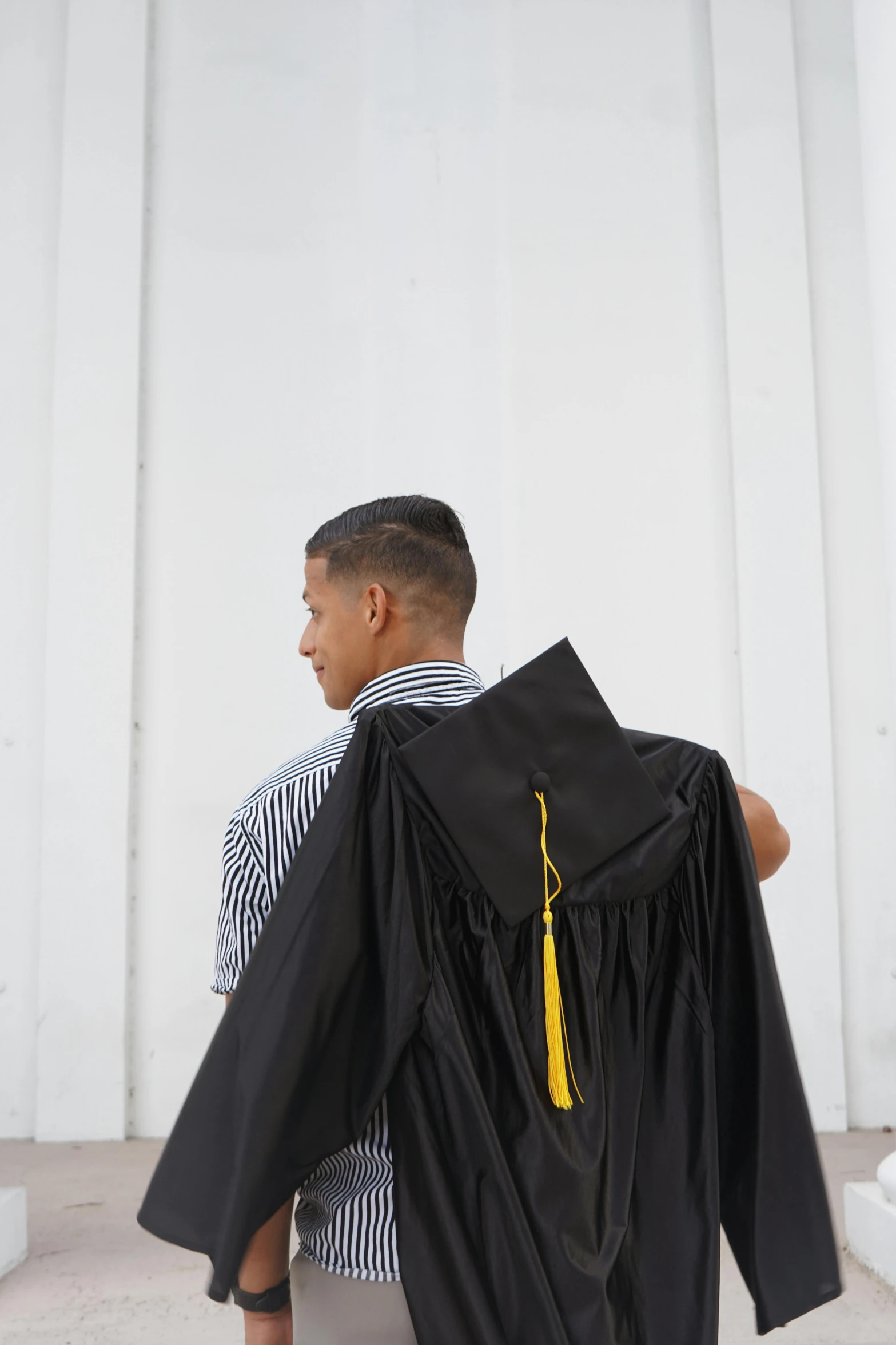 a graduate sits outside near a building