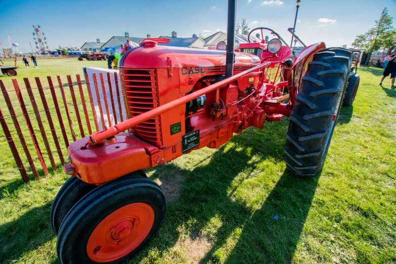 an old red tractor sitting in the grass