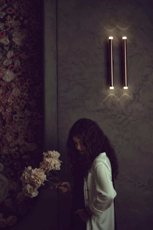 a woman standing in front of flowers on a ledge