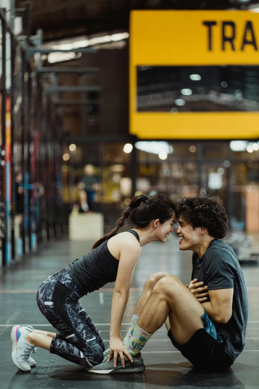 two people sitting on the floor of an industrial building