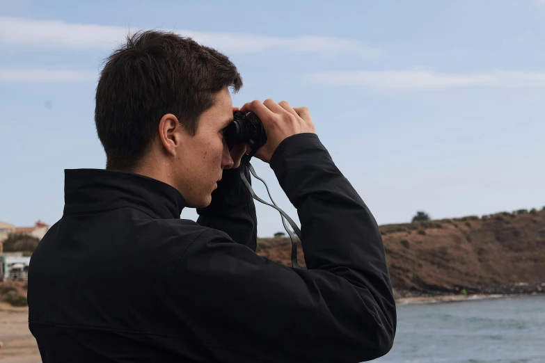 a man is looking at the water with his head close to his face