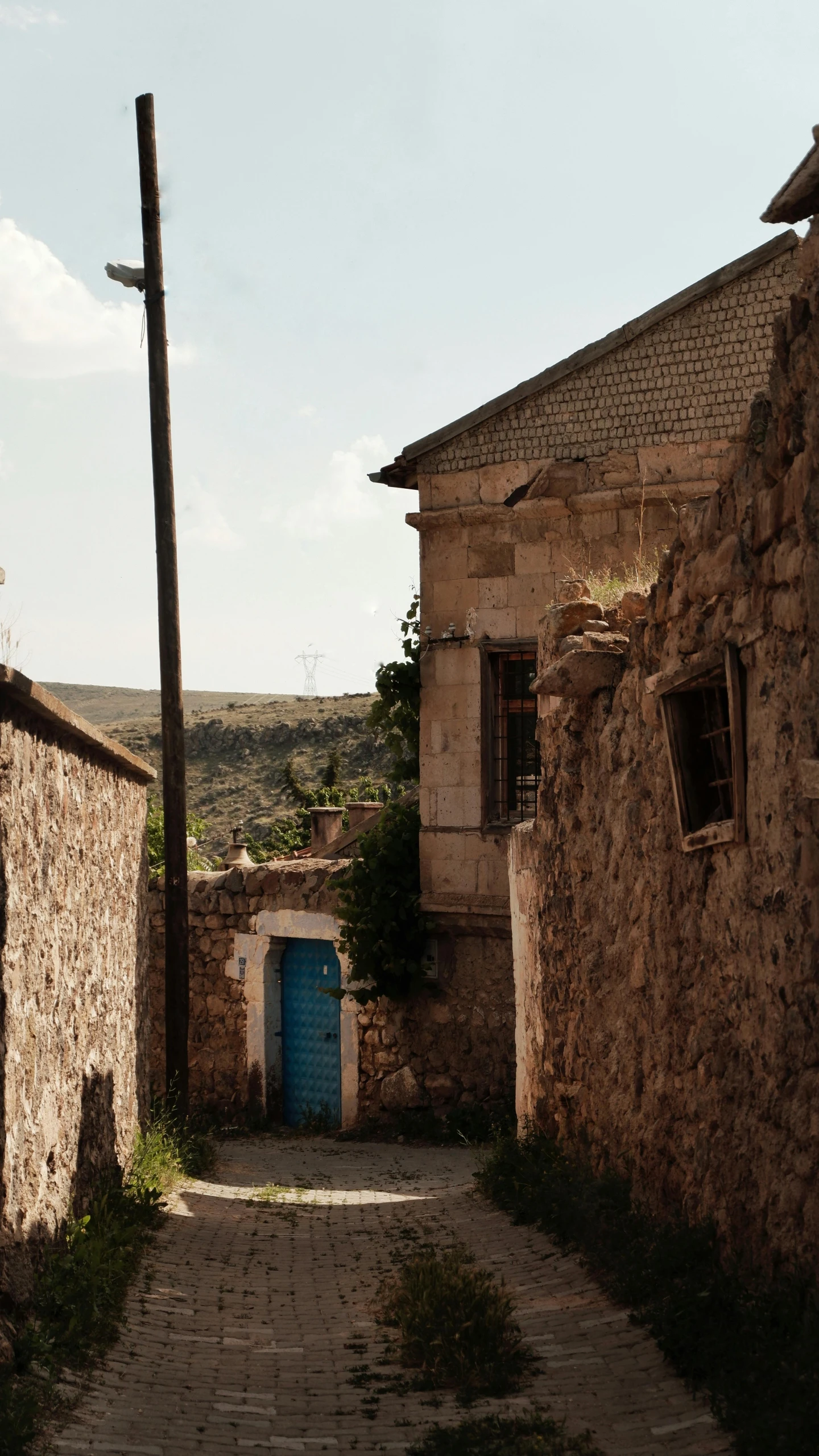 a narrow cobblestone road going between two buildings