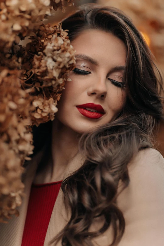 a woman holding dried flowers in her hair