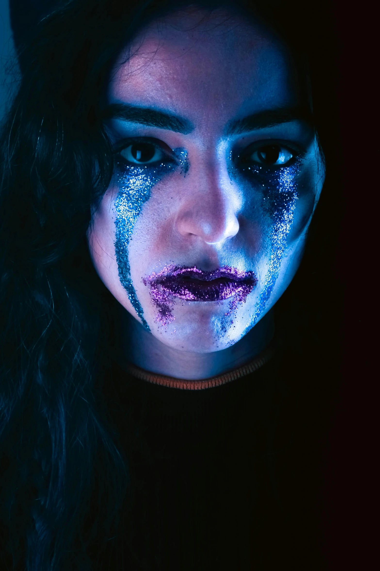 woman with blue face paint and makeup wearing black