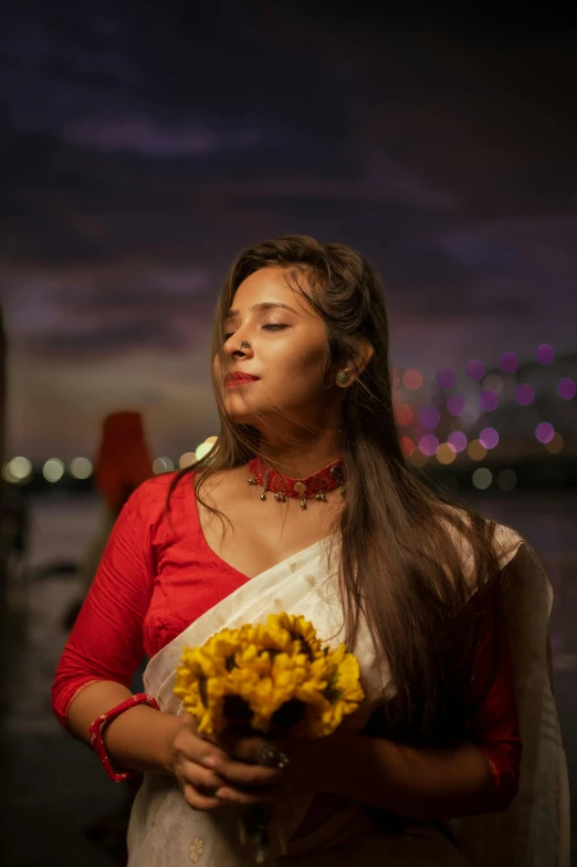 a woman is standing near the water at night