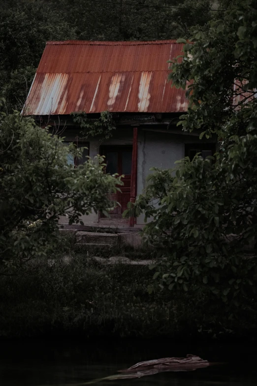 a small cabin near a forest that is covered in rust