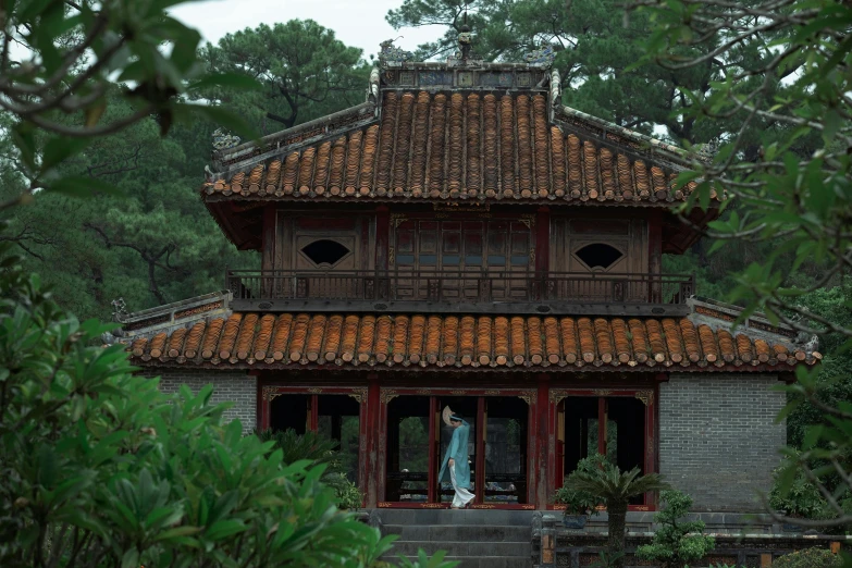 two people standing in a doorway near a building with a long stone path