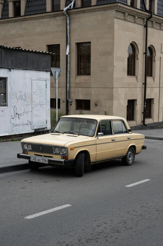 an old car parked on the side of a road near a building