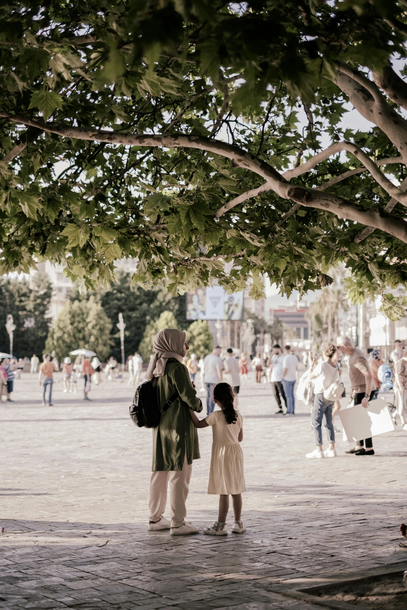 a group of people standing under a large tree