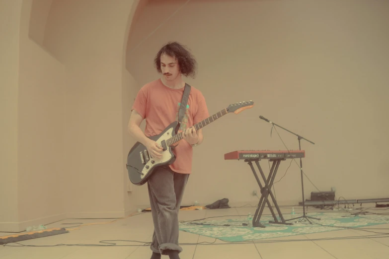 a man with a guitar standing on the floor