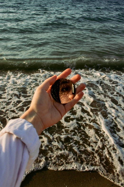 the person holds out a small object to see the water