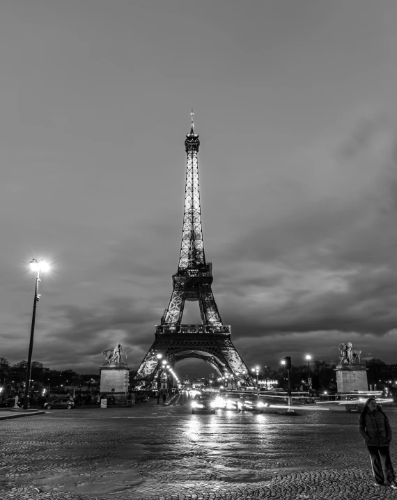 a man is standing near the eiffel tower