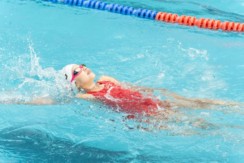 a boy in swimming gear swimming in the pool