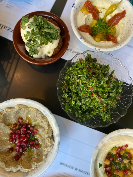 four bowls filled with assorted food items next to each other