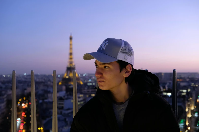the person wearing a baseball cap is standing at the top of a building