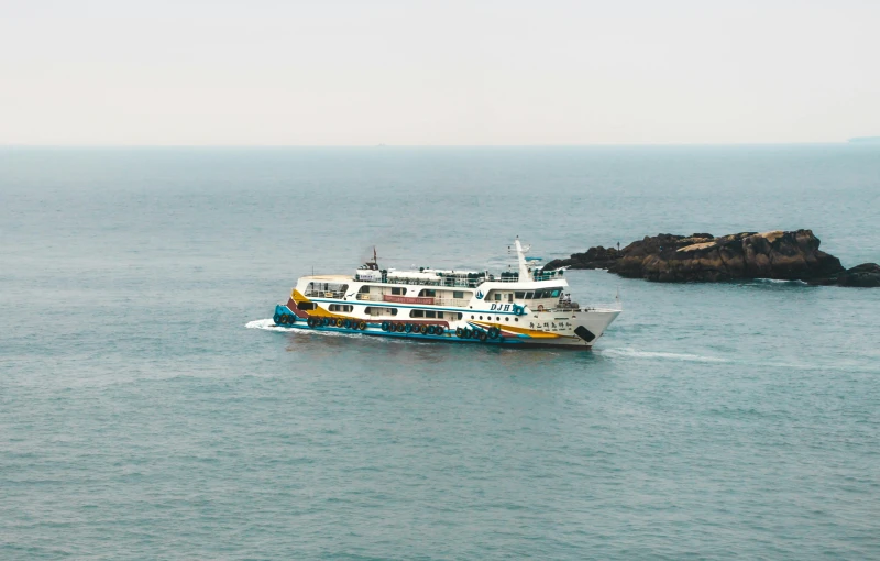 a boat traveling through the water near a rock formation