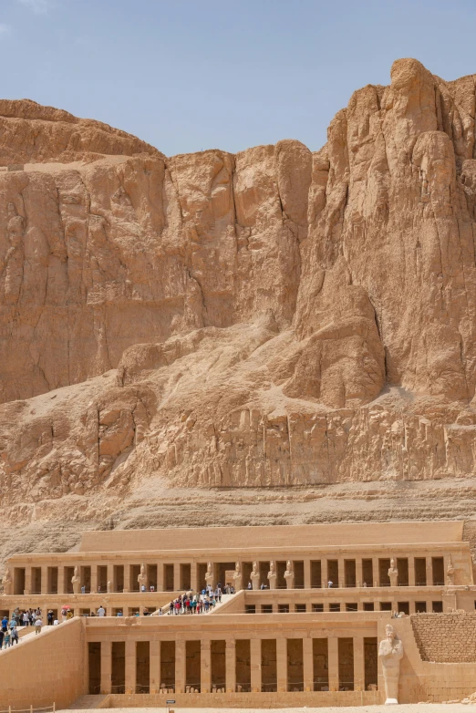 people are standing in front of an old stone structure