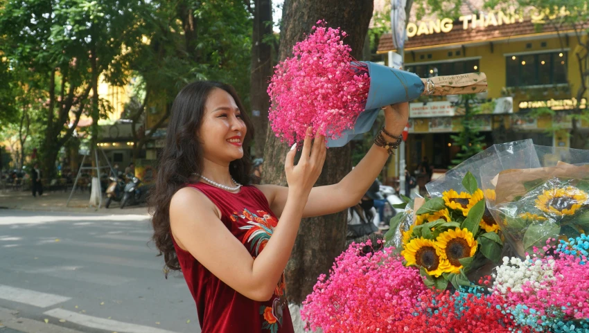 a woman standing next to a bunch of flowers