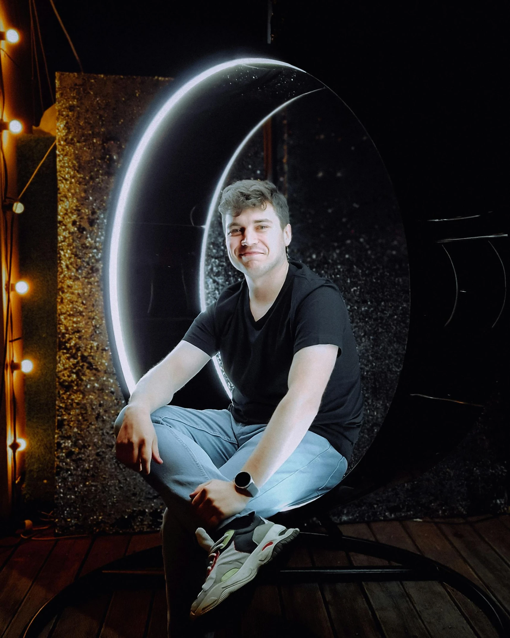 a guy sits on a floor in front of a mirror