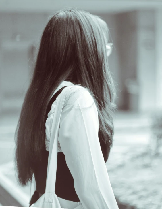 a girl is standing outside with her long hair in the wind