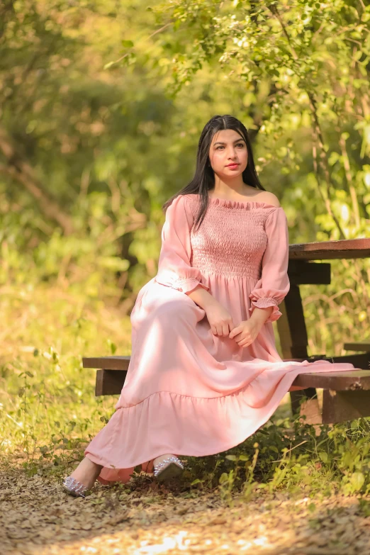 a girl is sitting on the bench and posing for the camera